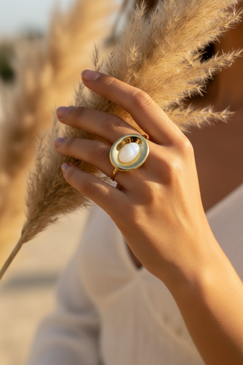 Femme portant la bague dorée pierre blanche - féminité sacrée